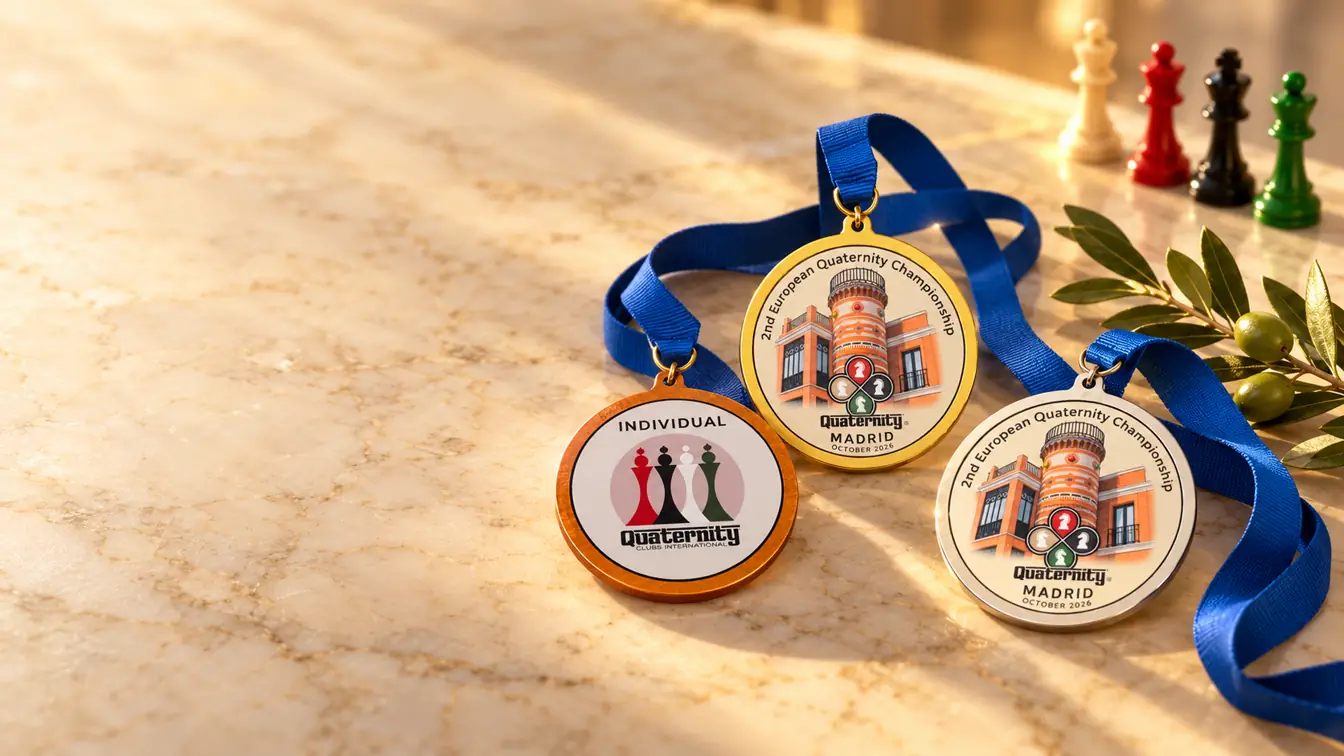 As medalhas do Europeu Madrid 2026 com fitas azuis sobre mármore: individual, ouro e prata, junto aos quatro reis.
